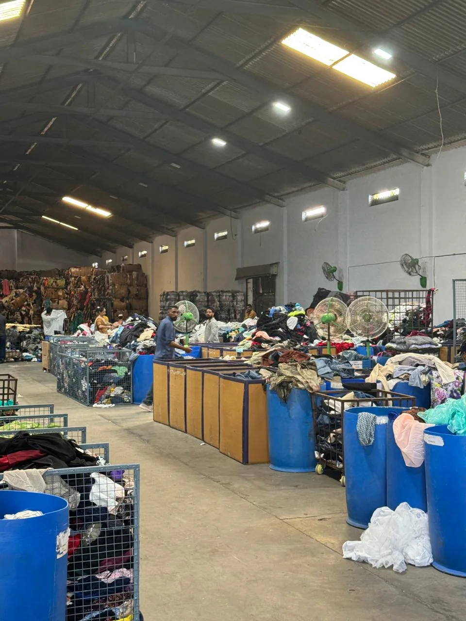 Rows of sorting bins and clothing inside a textile warehouse